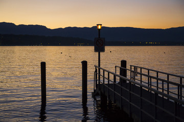 Fototapeta na wymiar Orange sunset and jetty on Lake Geneva