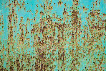 Green paint peeling off a metal plate, background.