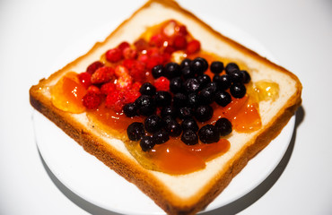 Sandwich with blueberries, strawberries and peach jam from breakfast