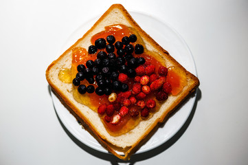 Sandwich with blueberries, strawberries and peach jam from breakfast