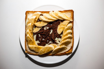 Sandwich with chocolate, condensed milk and a banana for breakfast