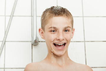 Vivacious young boy laughing in the shower