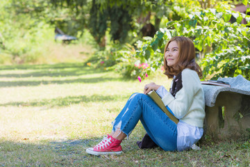 thoughtful woman sitting on grass alone