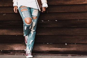 Young fashion woman's legs in jeans and shoes on wooden floor - Powered by Adobe