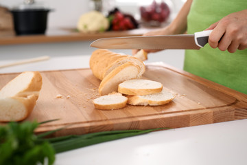 Close up of  woman's hands cooking in the kitchen. Housewife slicing ​​white bread. Vegetarian and healthily cooking concept