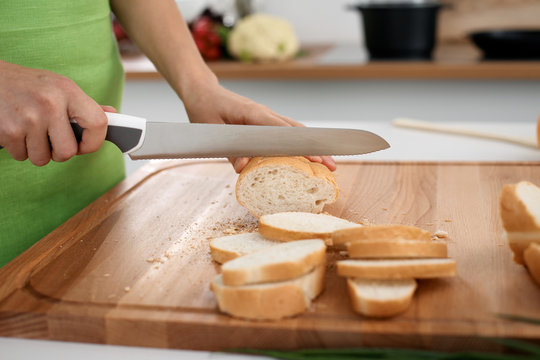 Close up of  woman's hands cooking in the kitchen. Housewife slicing ​​white bread. Vegetarian and healthily cooking concept