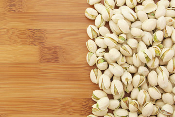 Pistachio nuts on wooden background