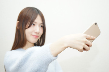 Naklejka premium Young woman taking selfie photos with smile