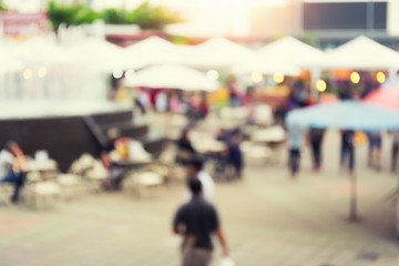 Blurred image of food fairs and food festivals consist of many booth and vendors at food stalls. Busy with asian people along the walking street. Event in Chiang Mai at twilight for background etc.