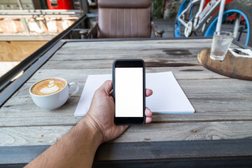 man hand holding mobile phone in coffee shop