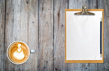 clipboard with paper pencil and coffee on table