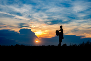 Silhouette, group of happy children playing on meadow, sunset, r