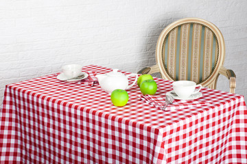 Beautiful decorated table with cutlery on the red checkered tablecloth
