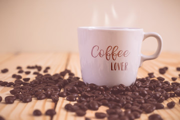 Coffee cup with Coffee lover text and coffee bean on wood table.