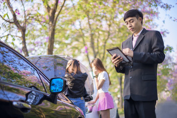 insurance agent review and inspect the dammage of the car after accident by device on line report to office for swift claiming against time consumption, both praty drivers in background