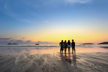Rolgordijnen groep gelukkige jonge mensen kijken op mooie zomerse zonsondergang op het strand © bobo1980