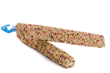 food for parrots on a stick isolated white background