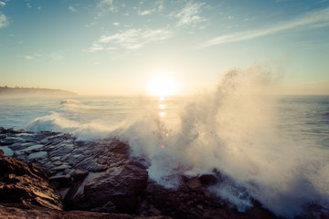 Waves crashing on the rocks at sunrise