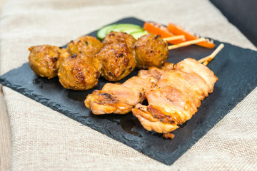 tasty grilled meat and vegetables skewers on a slate plate