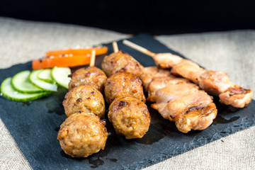 tasty grilled meat and vegetables skewers on a slate plate