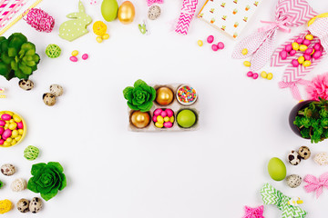 Easter eggs, candy and  succulent  in paper tray on spring decoration background. Flat lay, top view