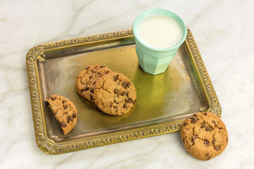 Chocolate chips cookies and milk on vintage tray