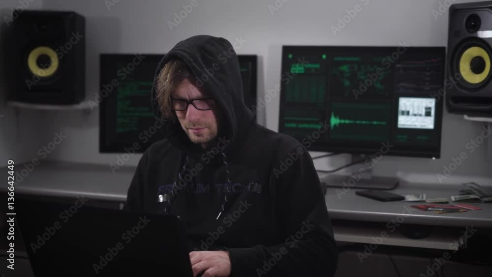 Poster a hacker in the computer room. the man with glasses and laptop on a hand trying to hack information 