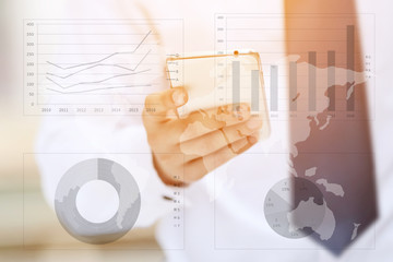 Asia business man hand touch screen on smartphone and business graph background.