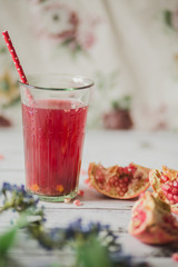 glass of pomegranate juice with fresh fruits on wooden table