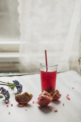 glass of pomegranate juice with fresh fruits on wooden table