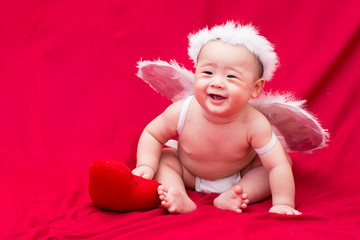 Baby cupid on red background