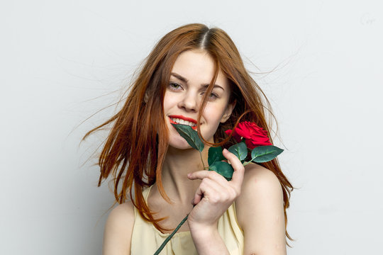 happy woman holding a red flower in her hand