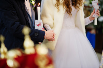 Groom hold brides hand at church on wedding ceremony.