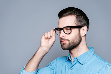 Portrait of smart confident teacher touching his glasses