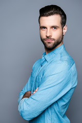 Portrait of serious young bearded businessman with crossed hands