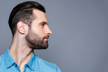 Side view of young stylish man isolated on gray background