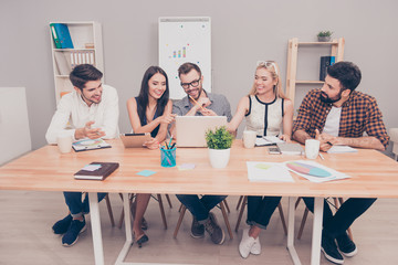 Happy creative business team using laptop in meeting at office