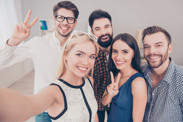Group of happy smiling businesspeople making selfie and gesturin