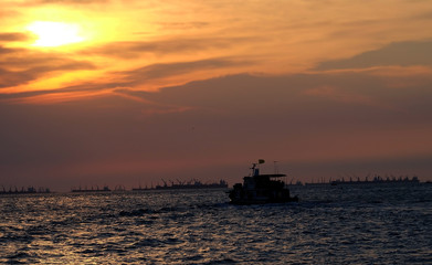 Fototapeta na wymiar Sunset on the beach with fisherman boat and mountain.