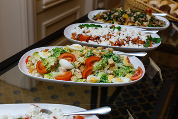 Delicious buffet table at a luxury event spread with a variety of cold meat platters and fresh colorful salad and vegetables