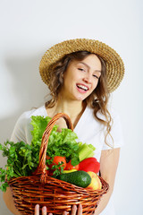 Laughing young woman with a basket full of healthy food