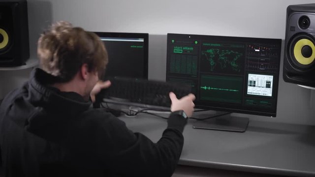 The man, looked like a hackers trying to enter on the keyboard of a computer code to hack the program, but he did not get angry, and he is knocks on your keyboard, throwing it on the table