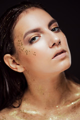 Close up portrait of beautiful woman with creative gold make up