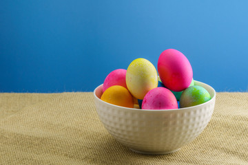 colored easter eggs on sackcloth blue background