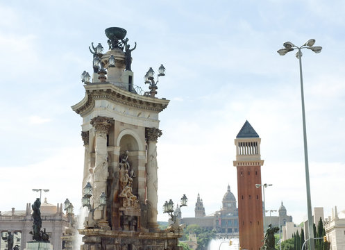 Marble sculpture monument and venetian tower in Plaza de Espana, on background National Art Museum, Barcelona