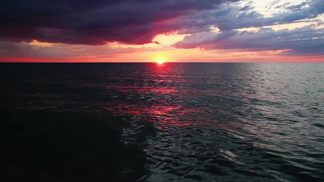 Loop features a dramatic sunset sky over waves on Lake Michigan. 