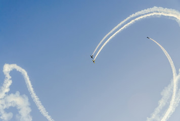 Aerobatic pilots with her colored airplanes training in the blue sky