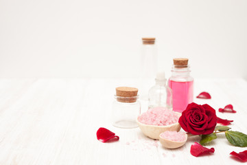 Fototapeta na wymiar salt, rose water from rose petals with your hands on a white woo