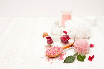 Fototapeta na wymiar salt, rose water from rose petals with your hands on a white woo