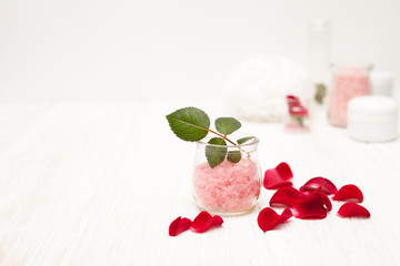 salt, rose water from rose petals with your hands on a white woo